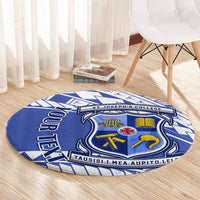 Round blue patterned rug on wooden floor with central crest and blue border