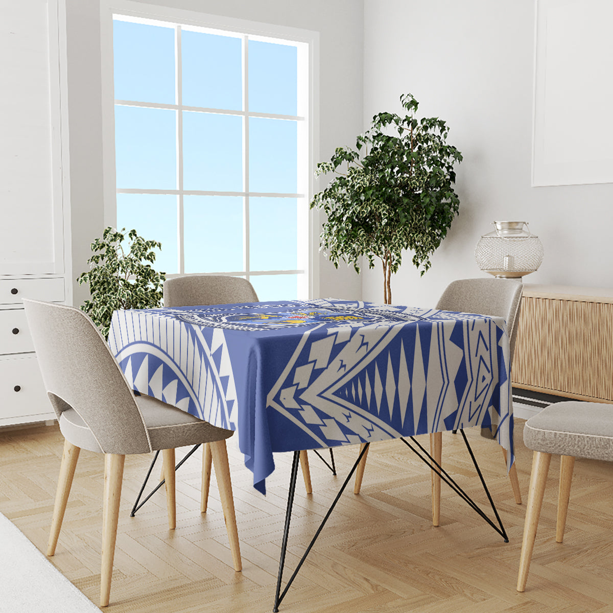 Blue geometric tablecloth covering dining table with four chairs