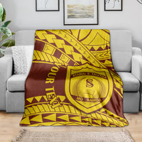 Maroon and gold shield-crest college blanket draped over a sofa