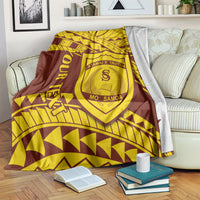 Maroon and gold shield crest blanket folded on a bed