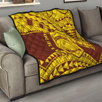 Gold and maroon quilt on a sofa, quilted geometric pattern with central shield crest