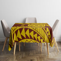 Gold and dark brown geometric tablecloth with crest motif on dining table