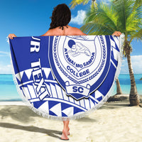 Blue round beach blanket with white fringe, geometric design and large circular college crest