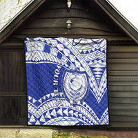 Blue and white Samoan pattern quilt with central crest emblem displayed on wall