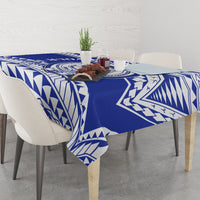 Blue and white geometric patterned tablecloth on a dining table with tableware