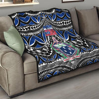 Blue and black Samoa 685 quilt draped on a sofa with central crest and patterned edges