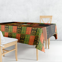 Black tablecloth with red, green, and yellow African motif draped over dining table