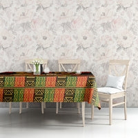 Black tablecloth with red, green, and yellow African geometric pattern on dining table