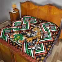Personalized quilt blanket with leopard and green, orange, black African geometric pattern on bed