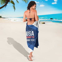 Blue and white sarong towel with USA Rugby 7s logo and text, worn on beach