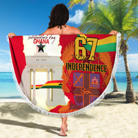 Round red Ghana beach blanket with 67 Independence design, held on sunny beach with palms