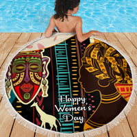 Round beach blanket with fringe, African portrait pattern and "Happy Women’s Day" lettering.