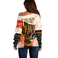 White off-shoulder sweater, long sleeves, colorful African-style back graphic