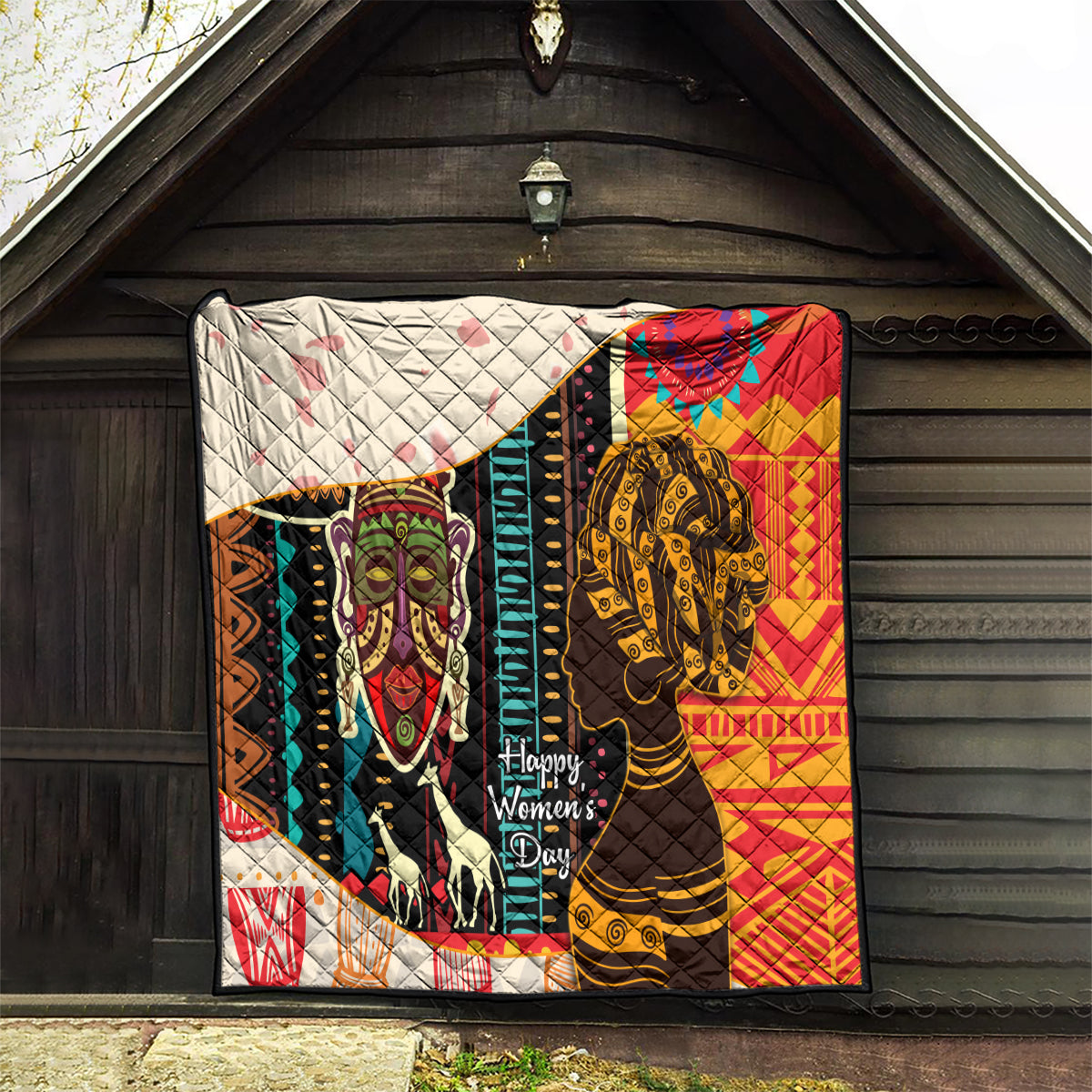 Women's African quilt blanket hanging outdoors with bold portraits, multicolor, quilted backing, Happy Women's Day.
