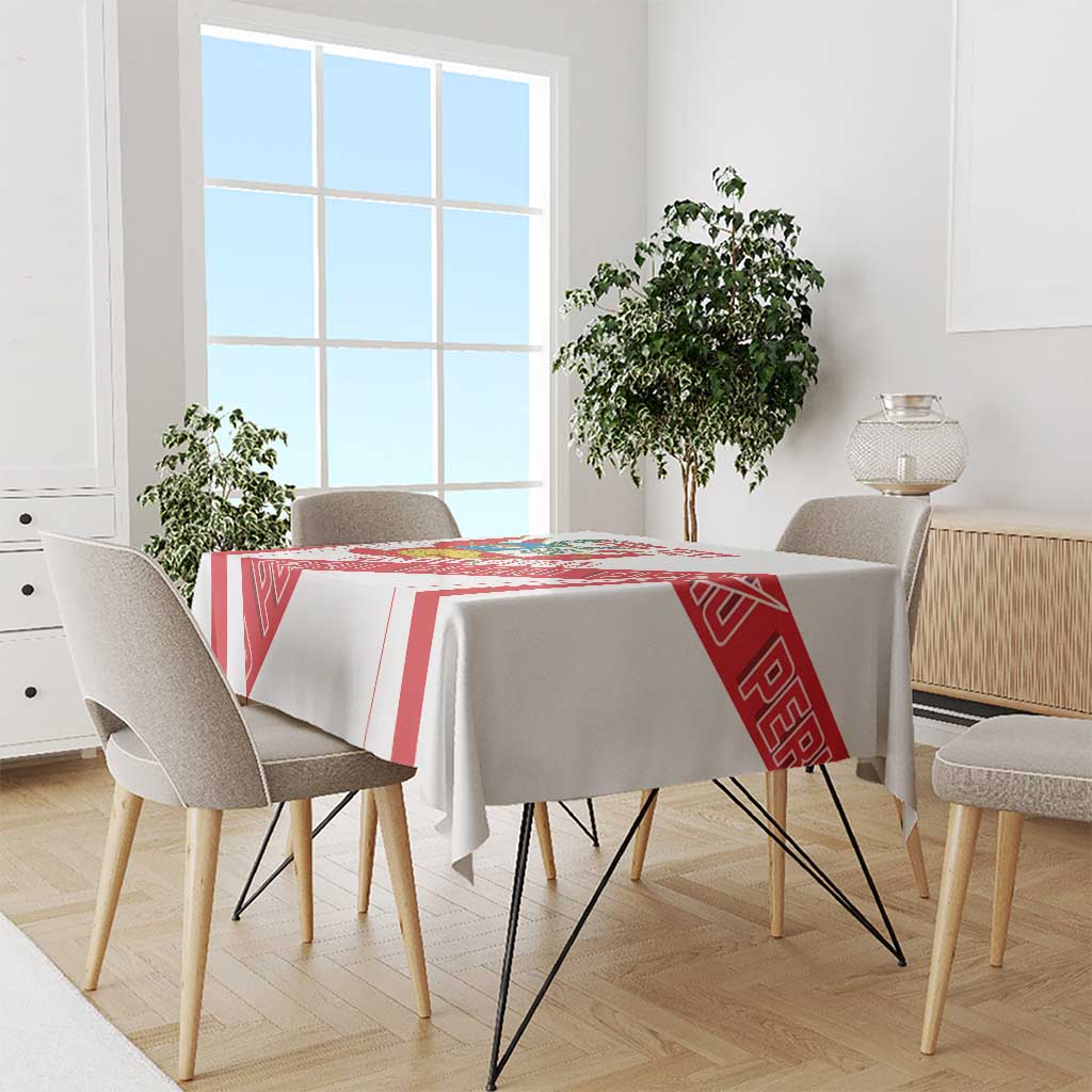 White tablecloth with red border stripes and Peru crest panel on dining table