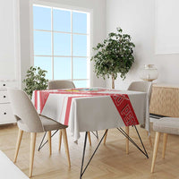White tablecloth with red border stripes and Peru crest panel on dining table