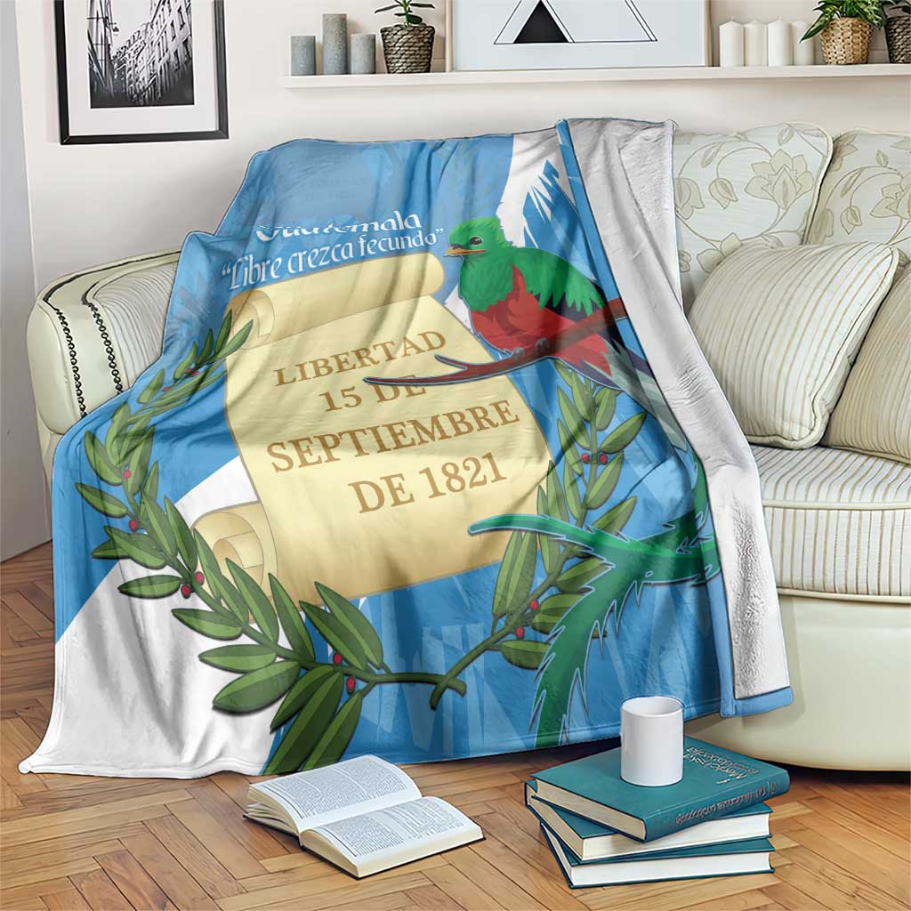 Blue and white blanket with Guatemala crest, quetzal bird and leaf accents