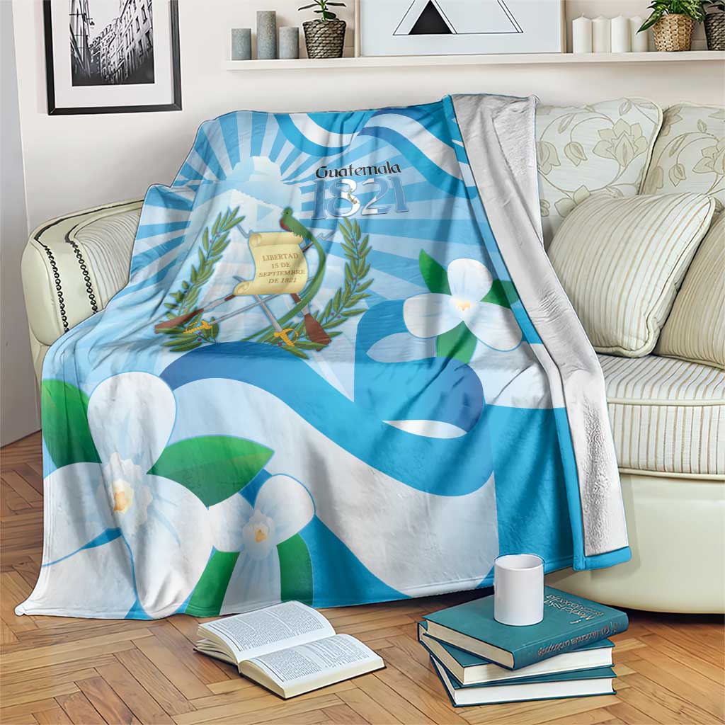 Blue Guatemala Independence Day blanket draped over sofa with coat of arms and flowers