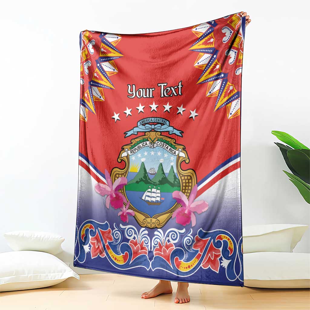 Personalized Costa Rica blanket held up, red and blue folk design with crest, stars and floral bows