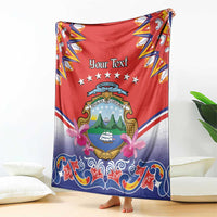 Personalized Costa Rica blanket held up, red and blue folk design with crest, stars and floral bows