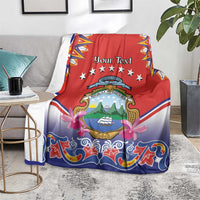 Personalized Costa Rica blanket spread on couch, red and blue folk pattern with crest