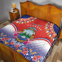 Personalized red quilt on wooden bed, Costa Rica crest and blue wave pattern