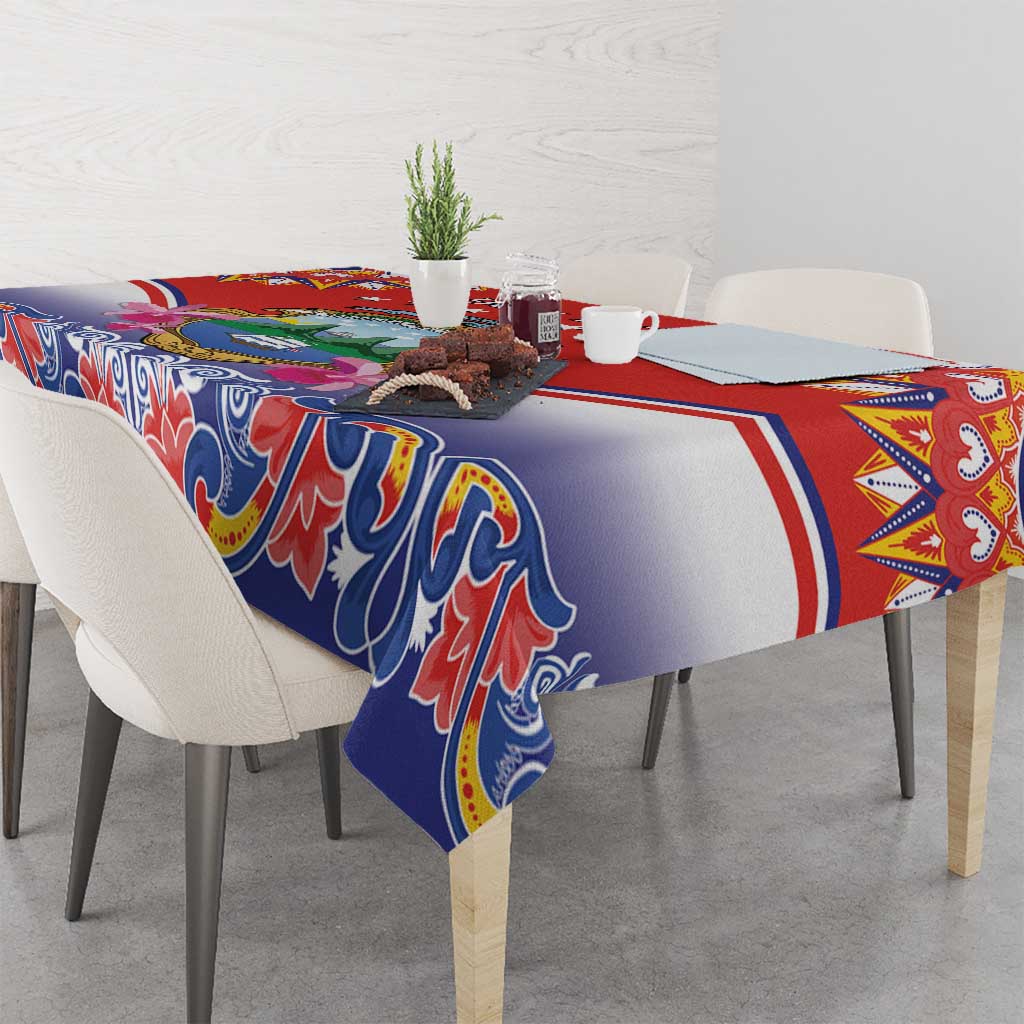 Red, blue, and white tablecloth draped over a table with folk border and ornamental design