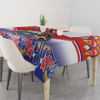 Red, blue, and white tablecloth draped over a table with folk border and ornamental design