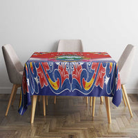 Blue and red folk patterned tablecloth with decorative swirls, draping evenly over chairs