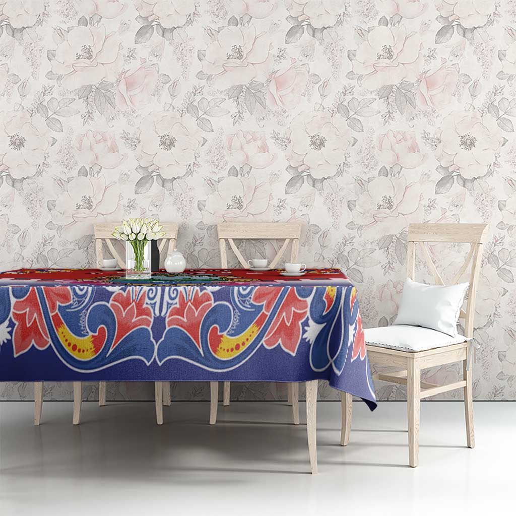 Blue and red folk patterned tablecloth with ornate border, styled on a dining table