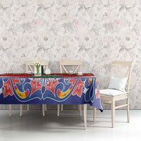 Blue and red folk patterned tablecloth with ornate border, styled on a dining table