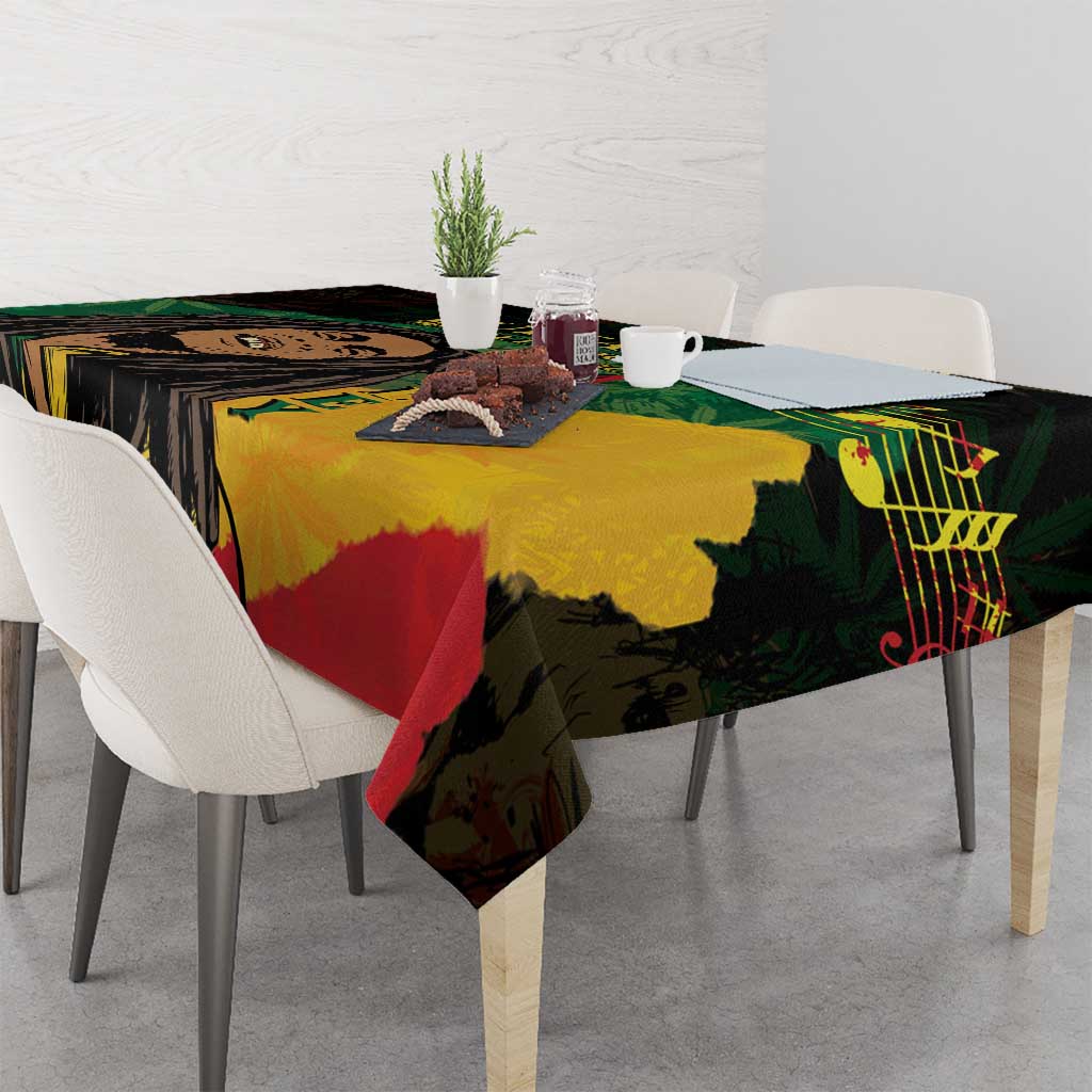 Black tablecloth with colorful reggae graphic artwork, laid across dining table with chairs