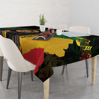 Black tablecloth with colorful reggae graphic artwork, laid across dining table with chairs
