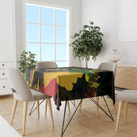 Black tablecloth with colorful reggae-style face and graphic motifs, draped on dining table