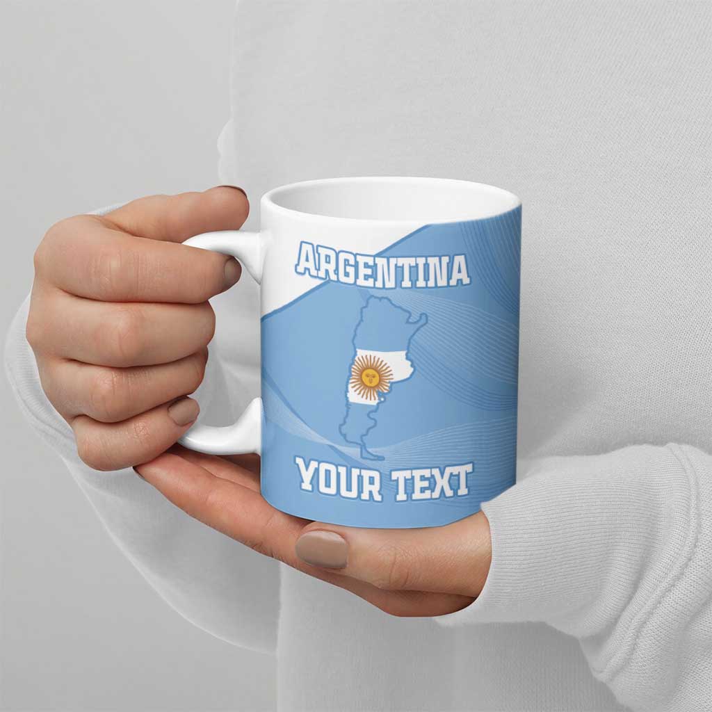 Blue ceramic football mug with Argentina map and 'YOUR TEXT', held by hand