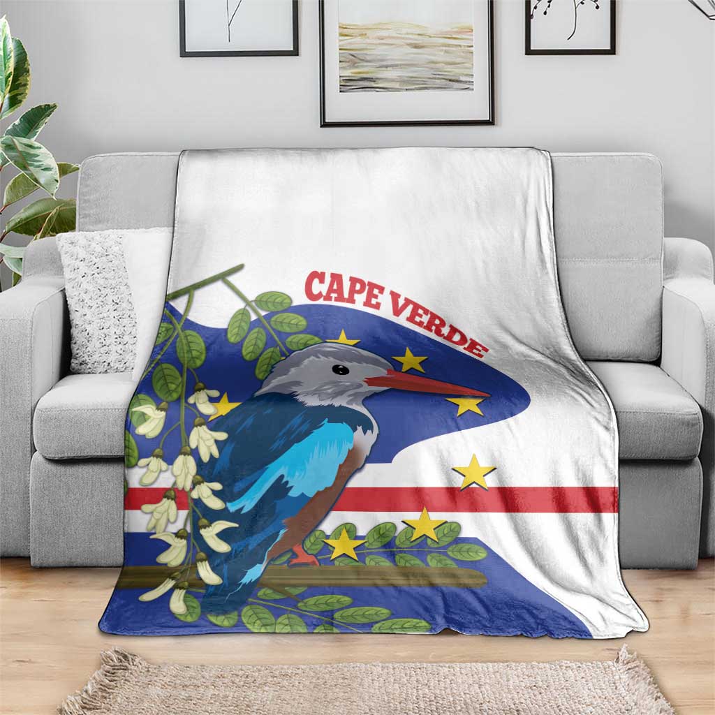 White and blue bird flag blanket folded on a grey sofa, covering the seat