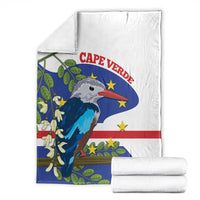 Folded white fleece blanket with blue flag bird graphic and matching folded edges