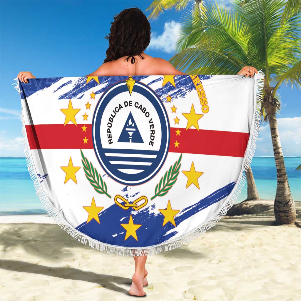 Person holding a round Cabo Verde beach blanket with crest, blue white red star pattern, fringe