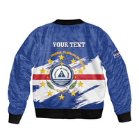 Blue bomber jacket with 'YOUR TEXT' back, Cabo Verde crest over flag graphic, black hem