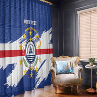 Blue Cape Verde coat of arms curtain panels with stars and red band, hanging beside a window.