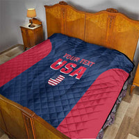 Blue and red USA quilt with diamond stitching and 'YOUR TEXT' USA emblem on bed