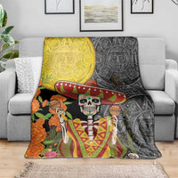 Dia de los Muertos blanket draped on sofa; colorful skeleton in sombrero with Aztec motifs