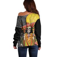 Women’s off-shoulder black sweater with back aztec pattern and large yellow face medallion