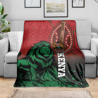 Red and green Kenya lion blanket draped over a gray sofa, showing crest and “KENYA”