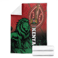 Red and green Kenya lion blanket folded, stacked white bundles beside it for comparison
