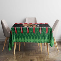 Christmas tablecloth with green diamond center and red striped edge on dining table.