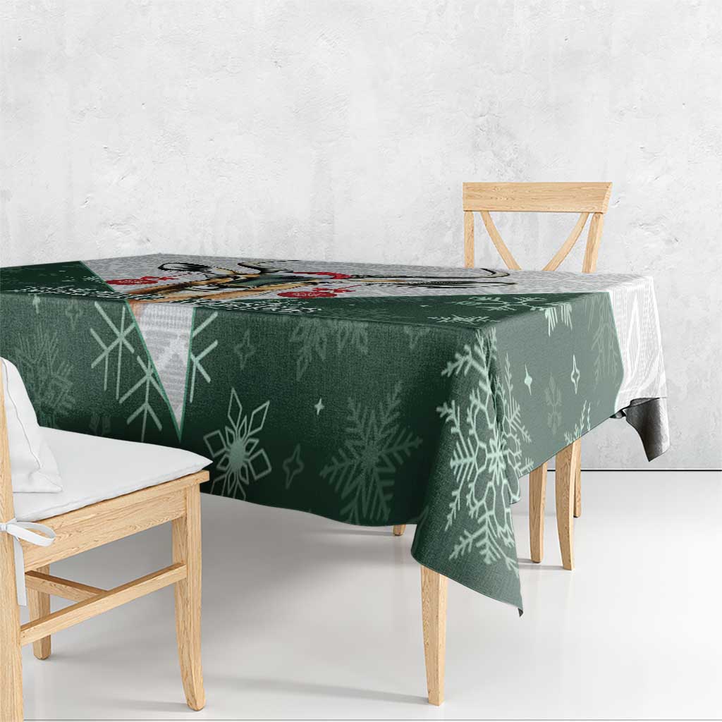 Green Christmas tablecloth with all-over snowflake pattern on a wooden bench