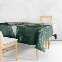Green Christmas tablecloth with all-over snowflake pattern on a wooden bench