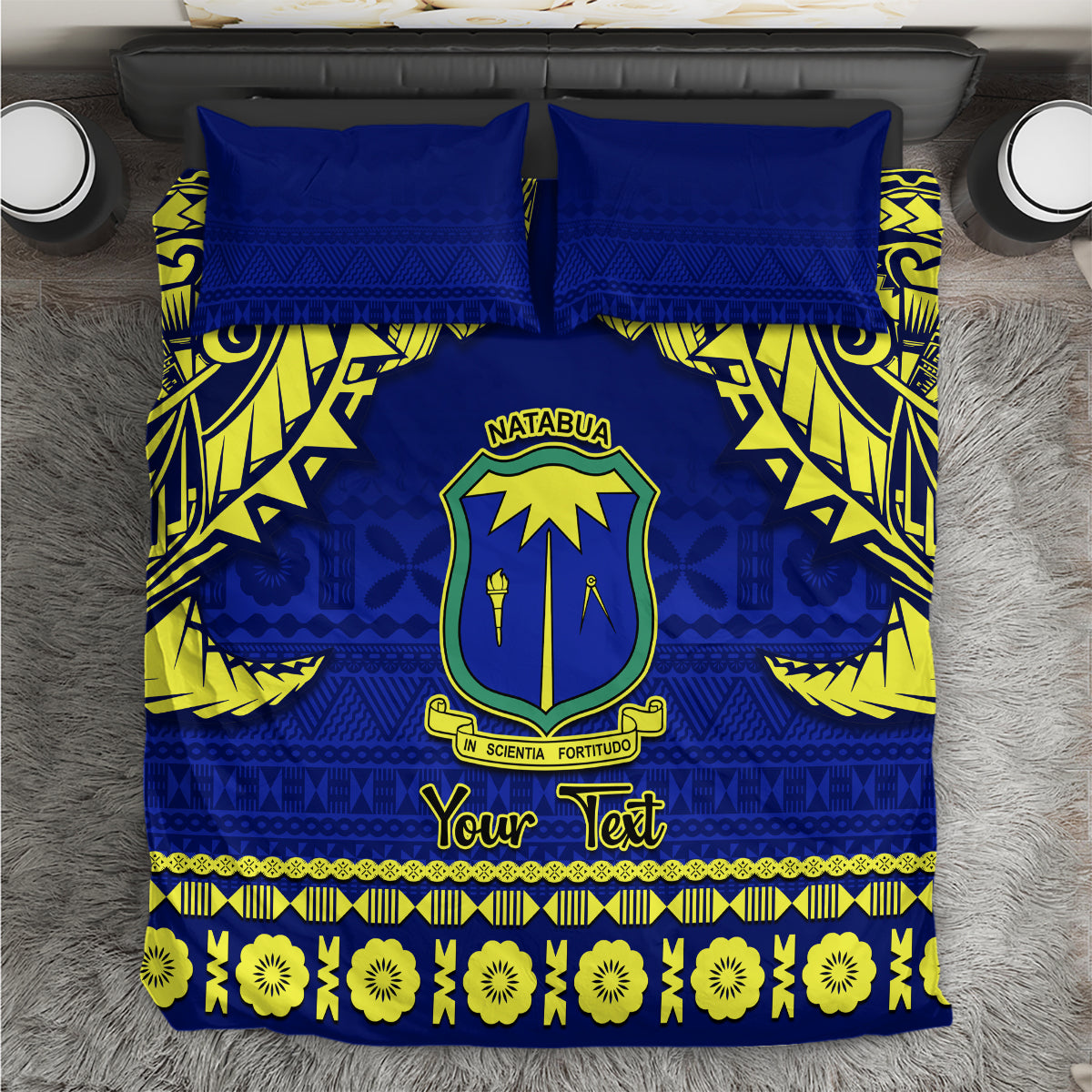 Blue bedding set with yellow tapa pattern, crest emblem, and 'Your Text' strip.