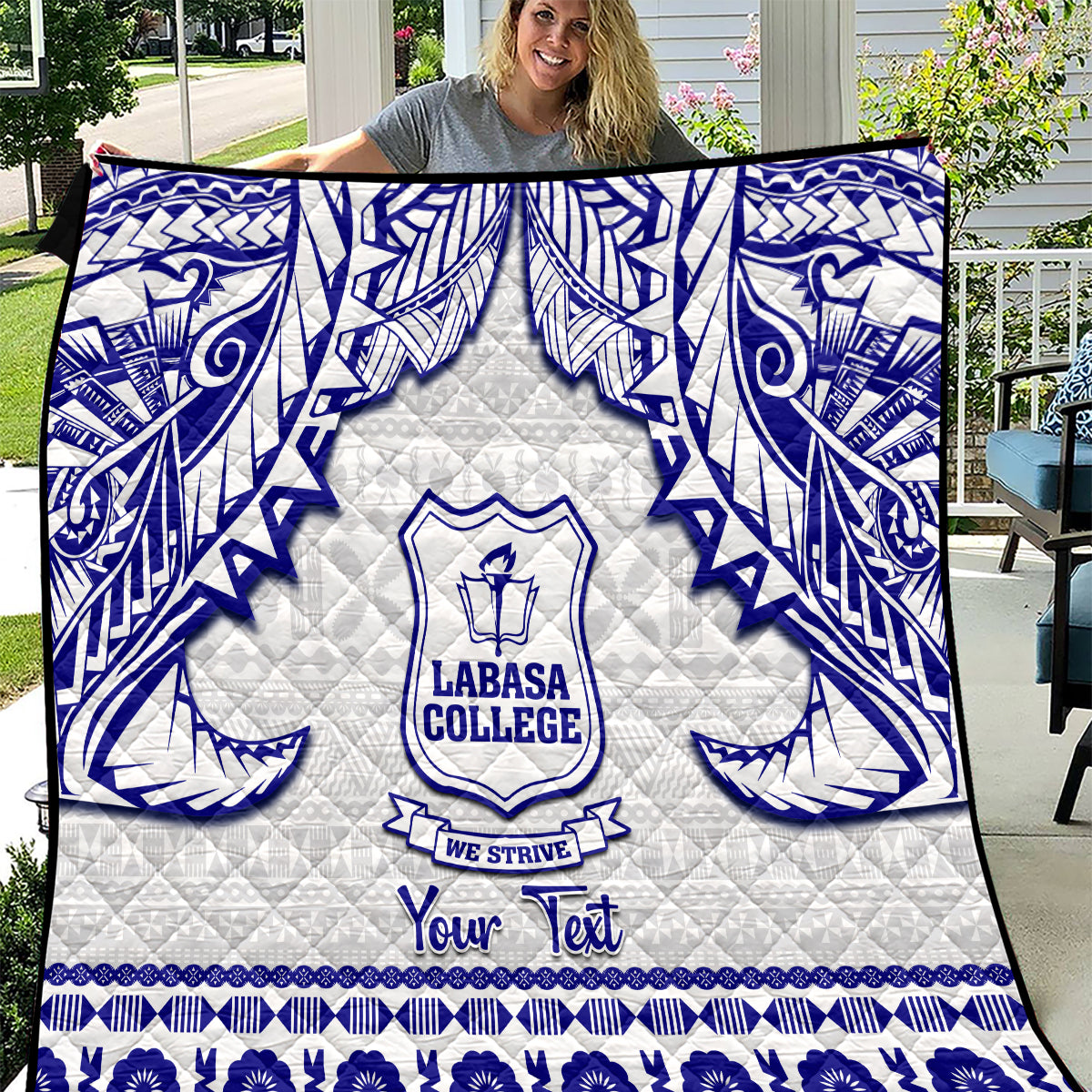 White and blue personalized quilt with tapa-style pattern and college crest, laid flat